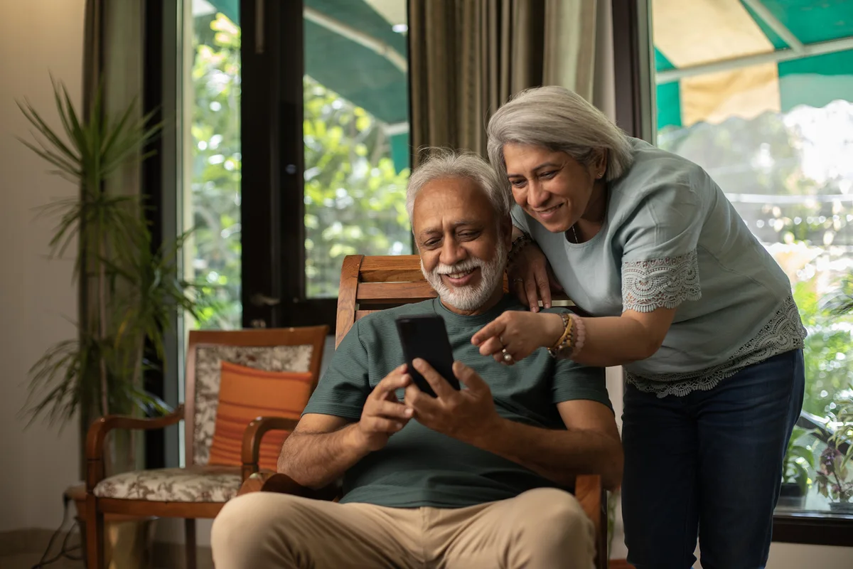 How Assisted Living Supports Couples with Different Needs Older couple sitting together smiling in their assisted care apartment at SweetBriar Villa, Springfield, OR.