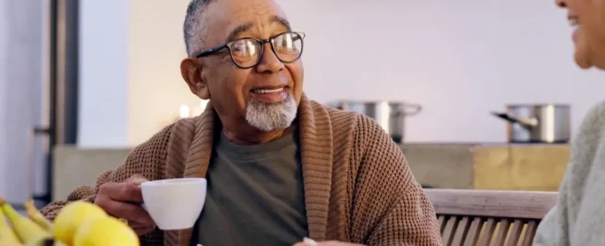 Assisted living levels of care: seniors chat over coffee and snacks in bright dining room