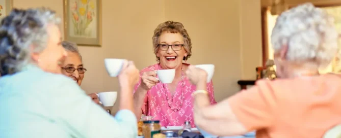 Senior Hispanic woman sitting with her adult daughter during a supportive conversation about assisted care vs memory care options